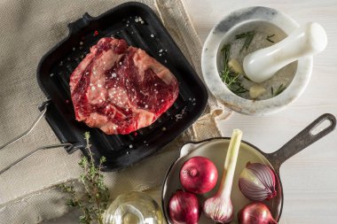 Büyük biftek ile otlar ve baharatlarla Marine ızgara tava üzerinde. Tarifi kitap gıda fotoğraf. Beyaz tahta arka plan