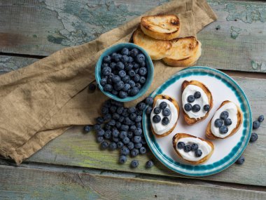 Meyve Bruschetta yayılmış peynir, taze çilek, ceviz ve bir sır bir ışık ahşap arka plan bal ve meyve sosu ile