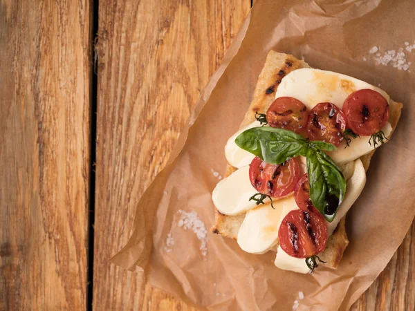 Close Delicioso Sanduíche Com Queijo Mussarela Tomate Pergaminho Sobre Mesa — Fotografia de Stock