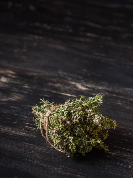 close-up of bunch of green dry herbs on black wooden table