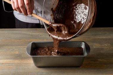 Ahşap masa arka plan üzerinde aşçı elle malzemelerle çikolata tatlı yemek.