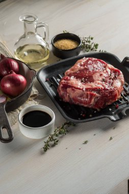 Büyük biftek ile otlar ve baharatlarla Marine ızgara tava üzerinde. Tarifi kitap gıda fotoğraf. Beyaz tahta arka plan