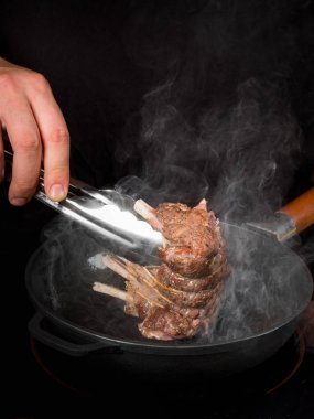 Erkek el metal tava üzerinde ızgara dana kaburga pişirme Close-Up