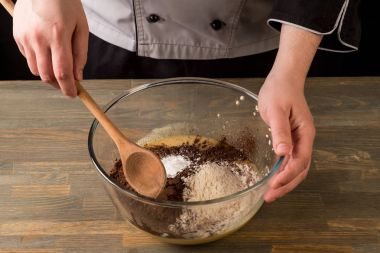 Çikolata tatlı malzemelerle cook tarafından el ahşap masa arka plan üzerinde yemek..