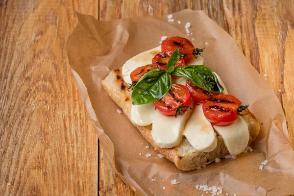 Close Delicioso Sanduíche Com Queijo Mussarela Tomate Pergaminho Sobre Mesa — Fotografia de Stock