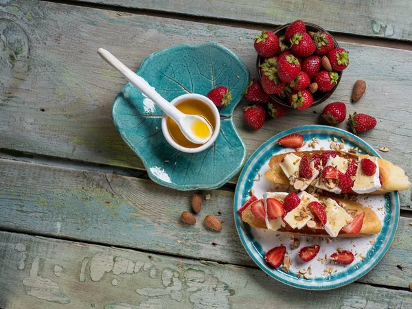 Bruschetta ile çilek, fındık yemek ve mavi ahşap rustik özgeçmişlerine camembert peyniri. Üstten Görünüm, düz yatıyordu, yukarıdan