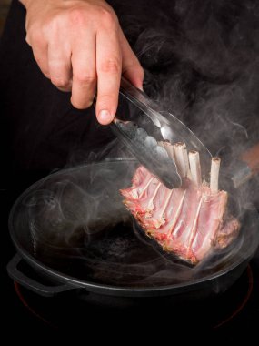 Erkek el metal tava üzerinde çiğ dana kaburga pişirme Close-Up