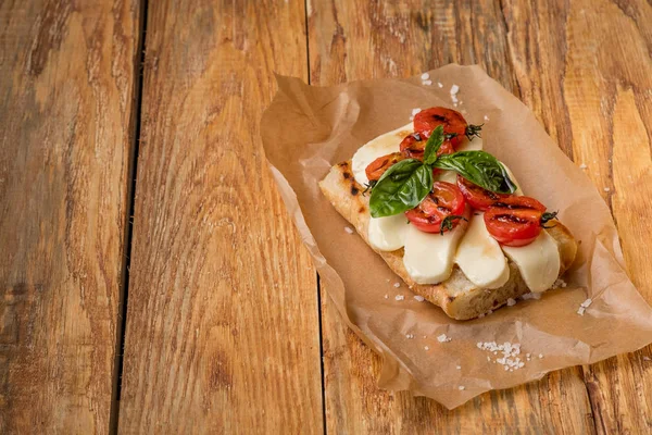 Close Delicioso Sanduíche Com Queijo Mussarela Tomate Pergaminho Sobre Mesa — Fotografia de Stock