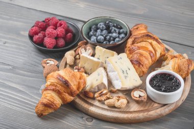 Peynir tatma brie ve mavi koyu arka plan üzerinde kruvasan ile çeşitli. Fransız gıda kavramı