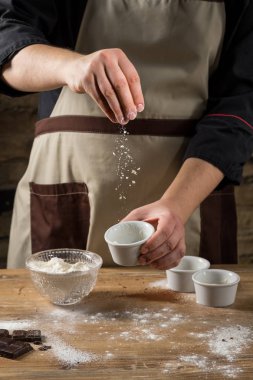 Şef pişirme kek cam kase hamur, un ve malzemeler ahşap arka plan