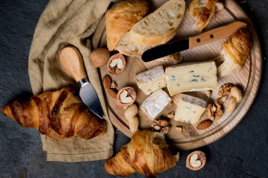 Peynir tatma brie ve mavi koyu arka plan üzerinde kruvasan ile çeşitli. Fransız gıda kavramı