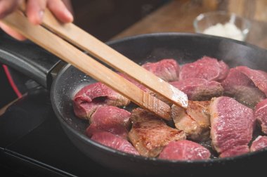 Bir tavada kızarmış etli bir yemek tarifi yemek pişirmek için çiğ et şef aşçılar