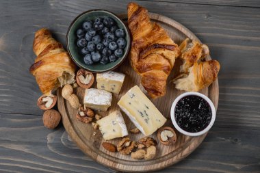 Peynir tatma brie ve mavi koyu arka plan üzerinde kruvasan ile çeşitli. Fransız gıda kavramı