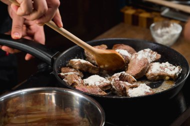 Bir tavada kızarmış etli bir yemek tarifi yemek pişirmek için çiğ et şef aşçılar