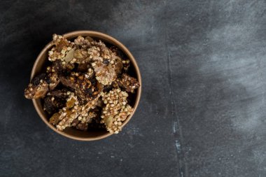 Granola siyah arduvaz arka plan üzerine ahşap kase, kopya alanı ile üst görünüm
