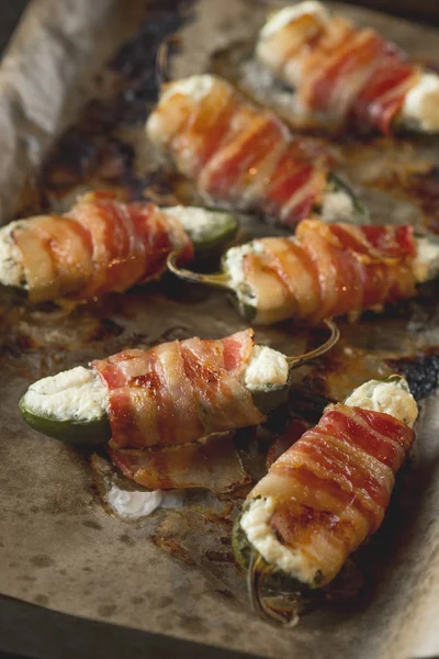 Jalapeno peppers with cheese and meat bacon. Food recipe on wooden background