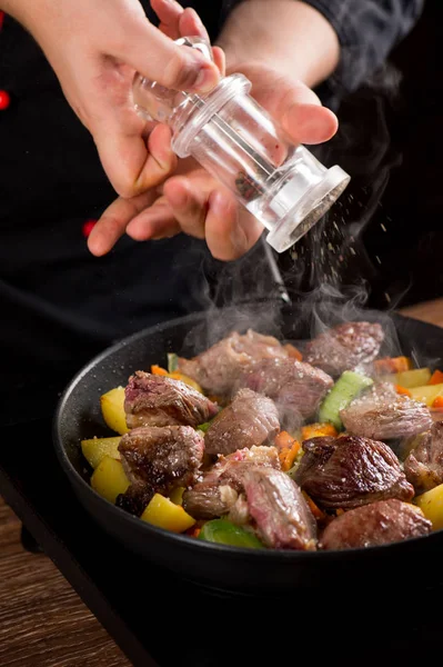 Chef hands putting spices on meat and vegetables in pan. — Stock Image Chef Hands Putting Spices Meat Vegetables Pan Stock Image