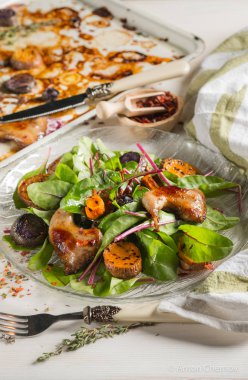 ızgara tavuk bacak beyaz metal tepsi ve cam plaka üzerinde taze yeşil yaprakları ile yakın çekim