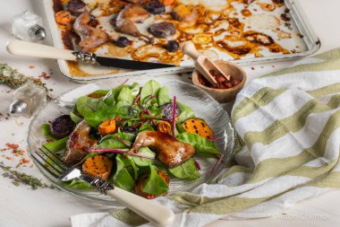 ızgara tavuk bacak beyaz metal tepsi ve cam plaka üzerinde taze yeşil yaprakları ile yakın çekim