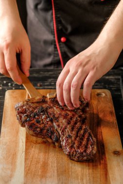 erkek ızgara et baharatlar ile ahşap tahta arka plan üzerinde tutan eller   