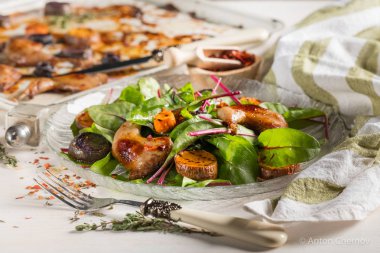 ızgara tavuk bacak beyaz metal tepsi ve cam plaka üzerinde taze yeşil yaprakları ile yakın çekim