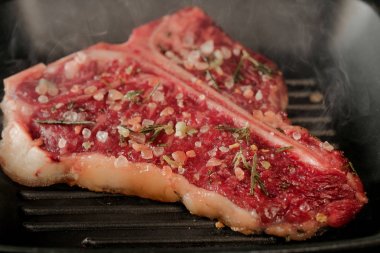 metal siyah ızgara tava zemin üzerine baharat ile çiğ et 