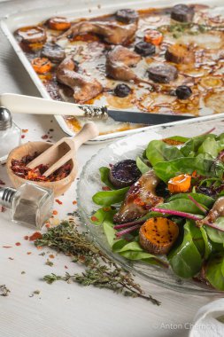 ızgara tavuk bacak beyaz metal tepsi ve cam plaka üzerinde taze yeşil yaprakları ile yakın çekim