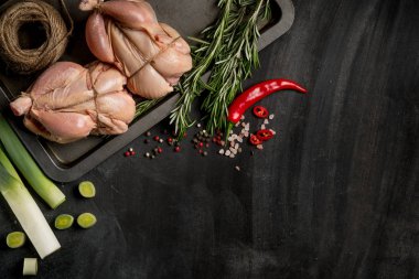 Otlar ve baharatlar siyah mutfak masasında kopya alanı ile tavuk pişirme