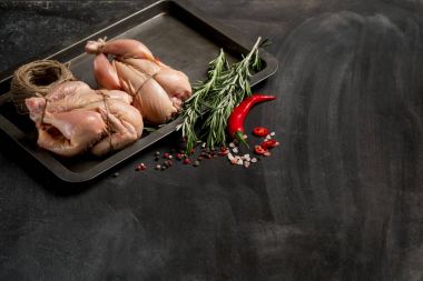 Otlar ve baharatlar siyah mutfak masasında kopya alanı ile tavuk pişirme