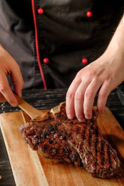 erkek ızgara et baharatlar ile ahşap tahta arka plan üzerinde tutan eller   