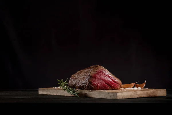 Carne Parrilla Con Ajo Romero Sobre Tabla Madera Sobre Fondo —  Fotos de Stock