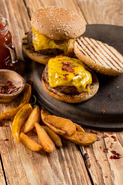 多汁汉堡包与土豆 乳酪和酱油在轻的木质背景与拷贝空间 — 图库照片
