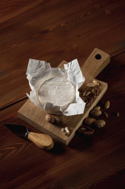 lezzetli beyaz Camembert peyniri ile fındık ve bıçak ahşap kesme tahtası üzerinde Close-Up