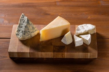 lezzetli peynir Parmesan, Camembert ve mavi peynir tablo arka plan üzerinde ahşap kesme tahtası üzerinde kümesi Close-Up