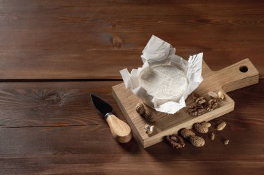 lezzetli beyaz Camembert peyniri ile fındık ve bıçak ahşap kesme tahtası üzerinde Close-Up