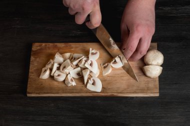 Tablo arka plan, ahşap tahta üzerinde bıçak ve kesme yenilebilir mantar holding erkek Şef eller Close-Up