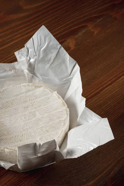 木製のテーブルの背景に白い紙の上おいしい白カマンベール チーズのクローズ アップ — ストック写真