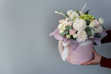 çiçekli pembe hediye kutusu tutan eller