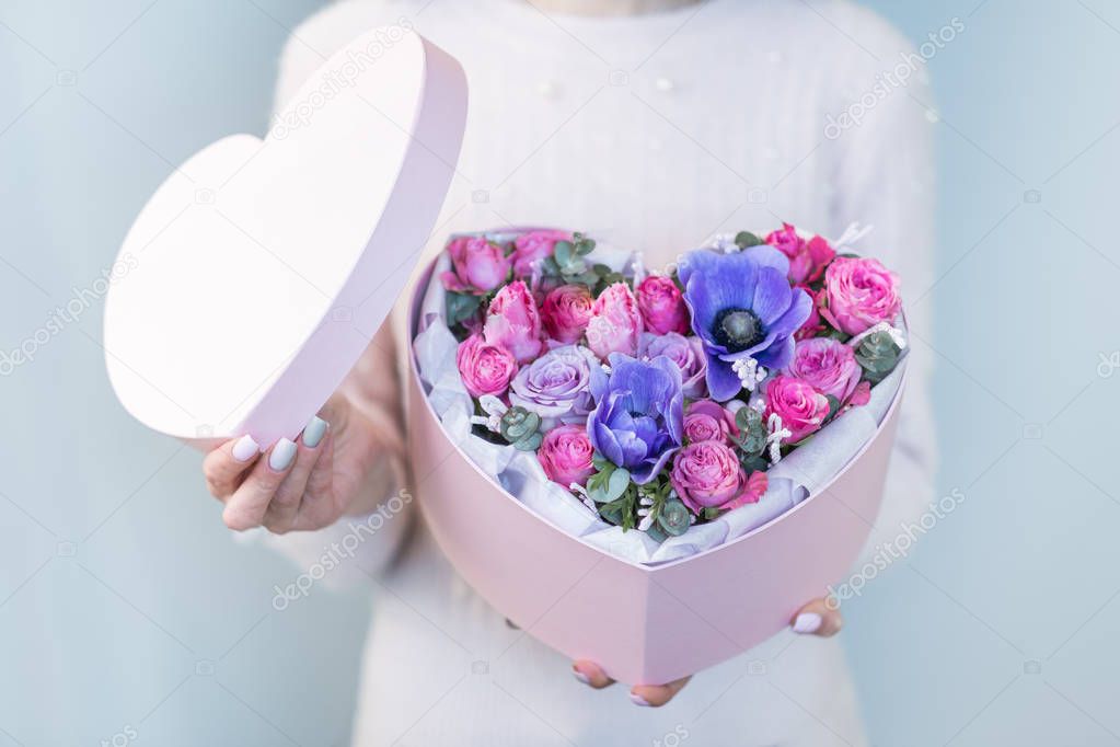crop image of woman holding open heart shaped gift box with flowers in hans