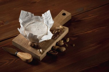 rustik düz brie peyniri ile yatıyordu kahverengi ahşap masa, kopya alanı ile üstten görünüm üzerinde kurulu otlar ve fındık ile kesme