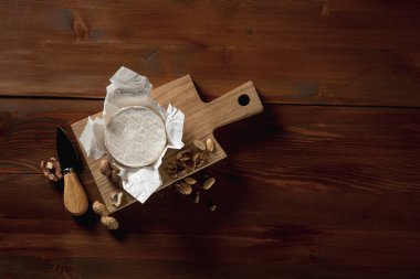 rustik düz brie peyniri ile yatıyordu kahverengi ahşap masa, kopya alanı ile üstten görünüm üzerinde kurulu otlar ve fındık ile kesme