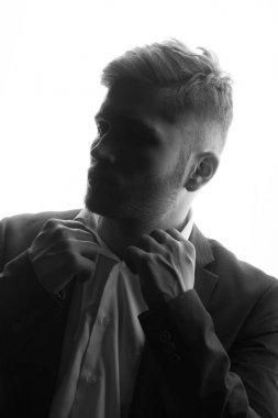 tek renkli gömleğinin yaka tutarak takım elbiseli genç adam portresi