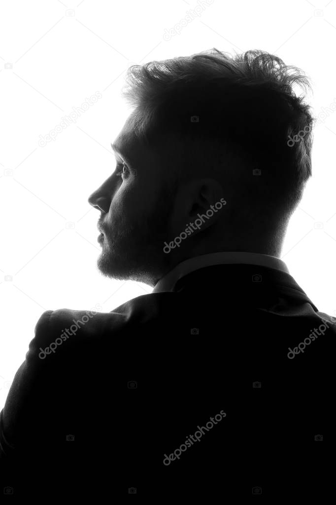 monochrome photo of young man in suit isolated on white background, side view