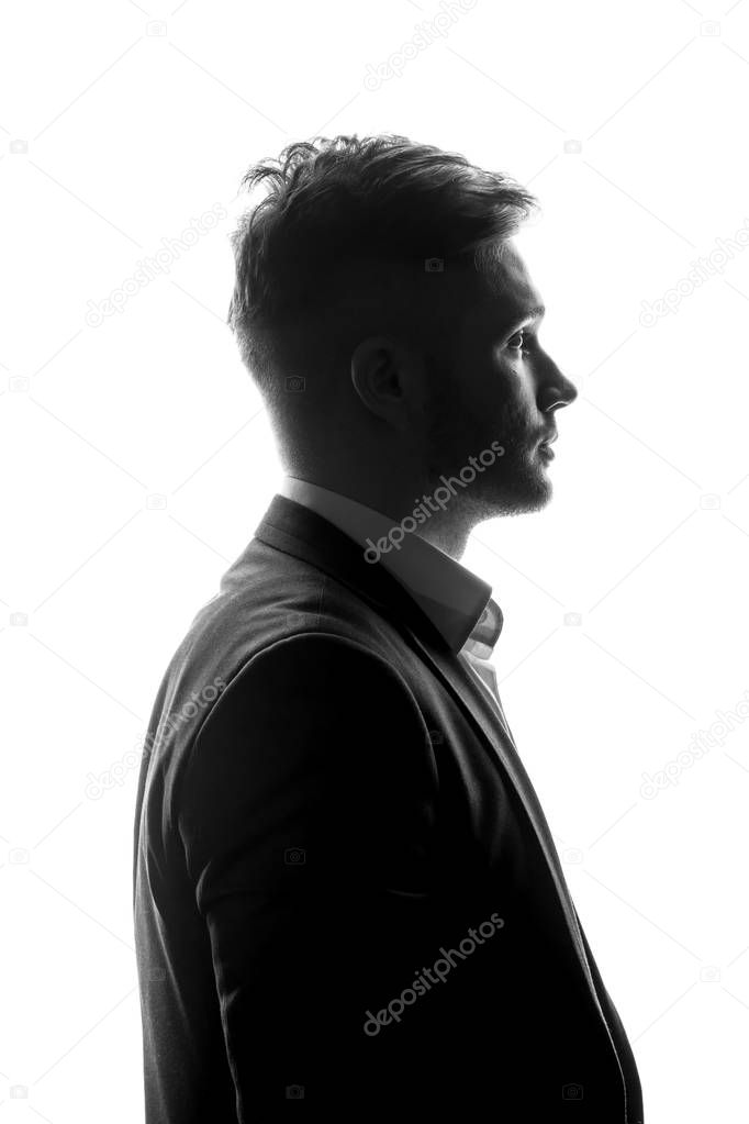 monochrome portrait of young businessman in suit standing on white background