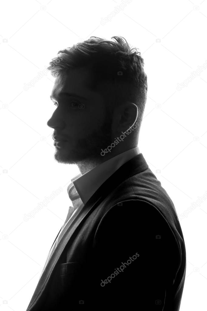 monochrome portrait of young businessman in suit standing on white background