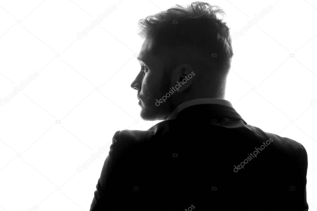 monochrome photo of young man in suit isolated on white background, side view