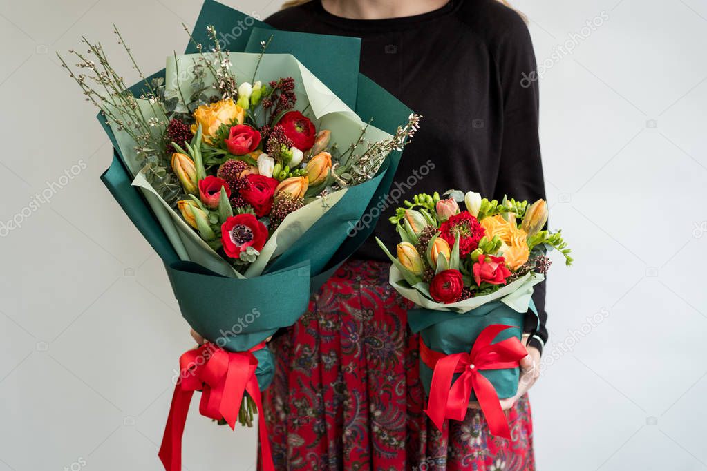 Woman holding two stylish bouquets of red flowers