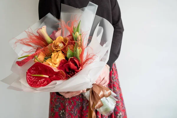 Kobieta Trzyma Jasny Bukiet Czerwonych Kwiatów Egzotycznych — Zdjęcie stockowe