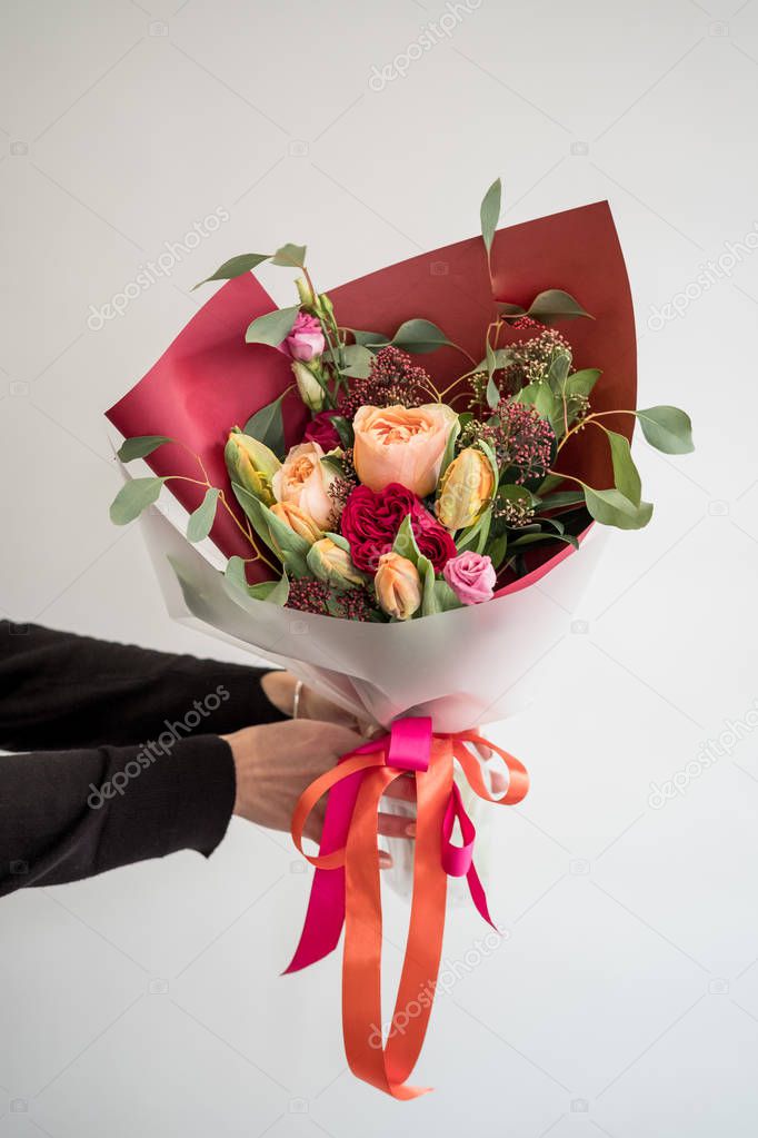 Woman florist making a lovely flower composition in a flower shop