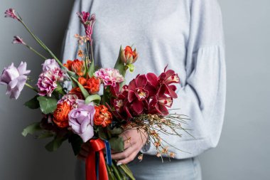 moda güzel bahar buket gri arka plan üzerinde tutan kadın fotoğrafı